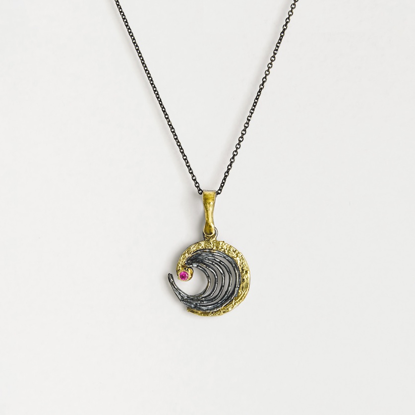 Spiral-shaped silver pendant with gold inlay and ruby