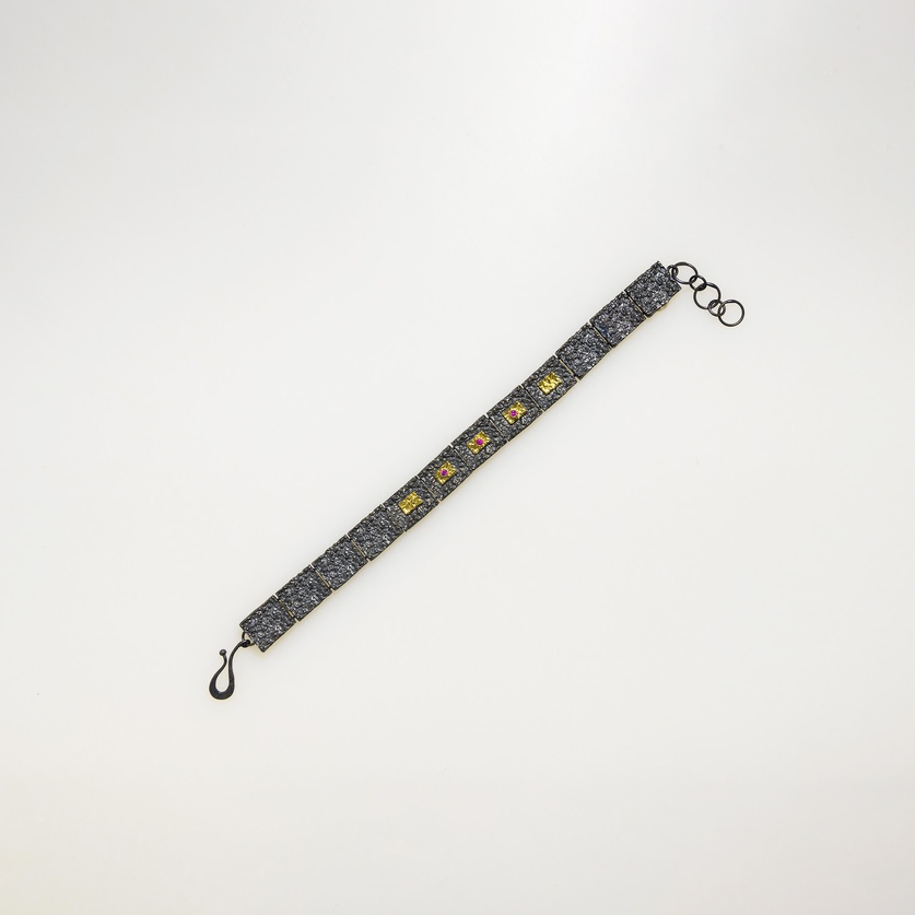 Rough surface bracelet in silver, gold inlay and rubies