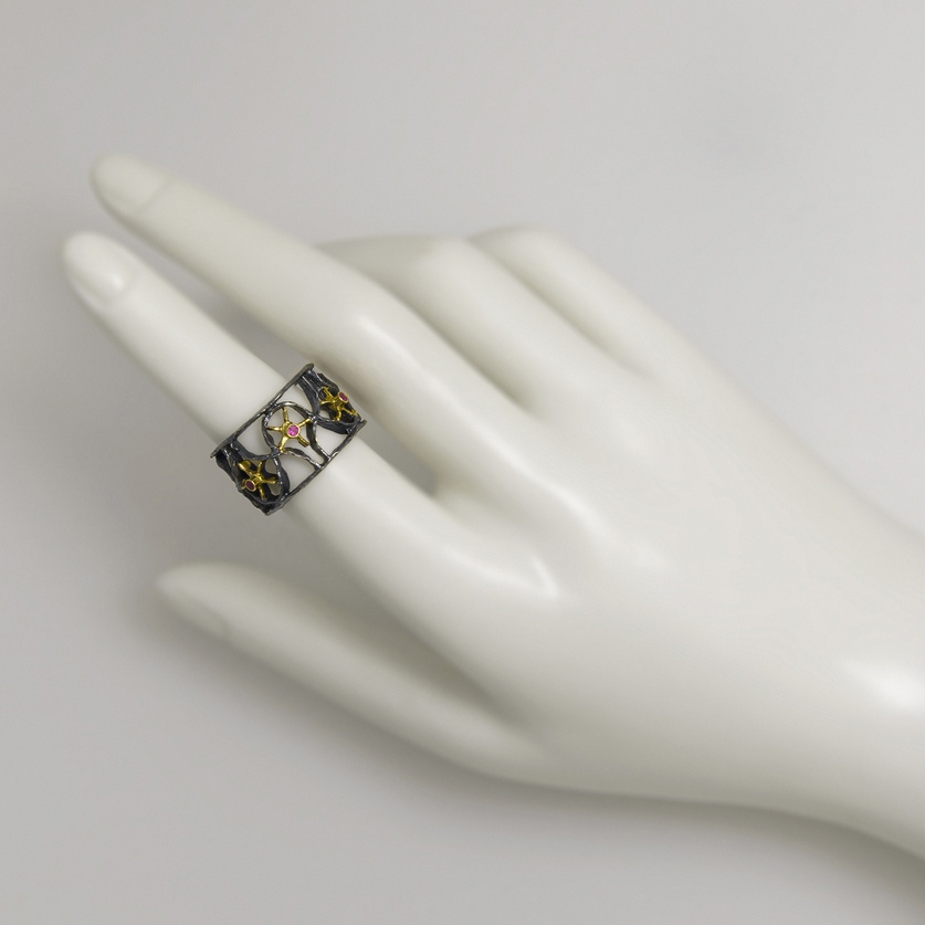 Silver ring of intricate detail with gold inlay and rubies