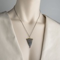 Silver pendant of modern design with gold inlay and ruby on the edge